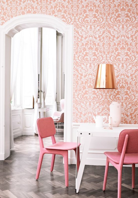 Zona comedor con papel pintado y sillas en color coral