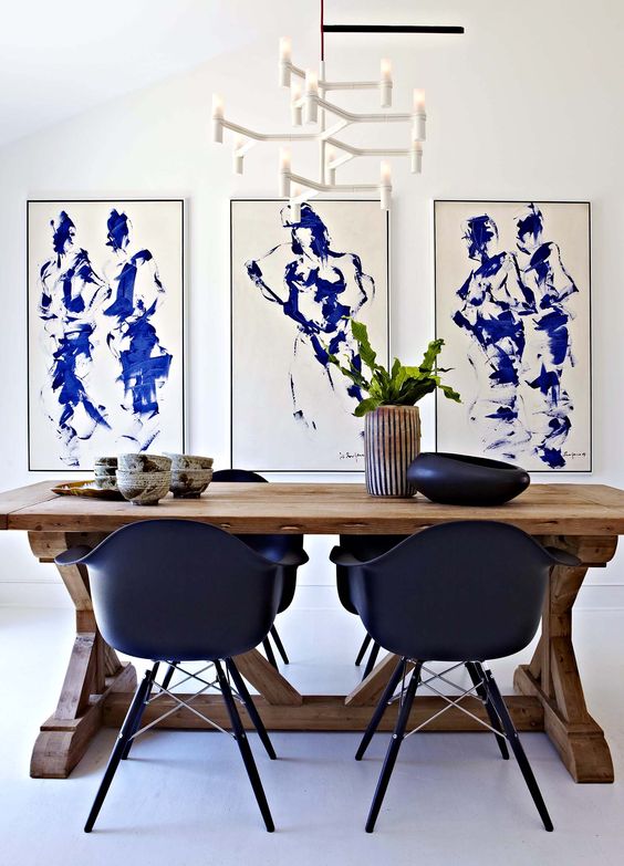 Comedor blanco decorado con sillas y cuadros en azul klein
