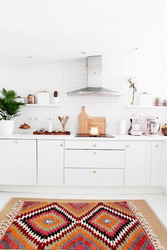 Cocina con muebles blancos con pequeño relieve y detalles en oro