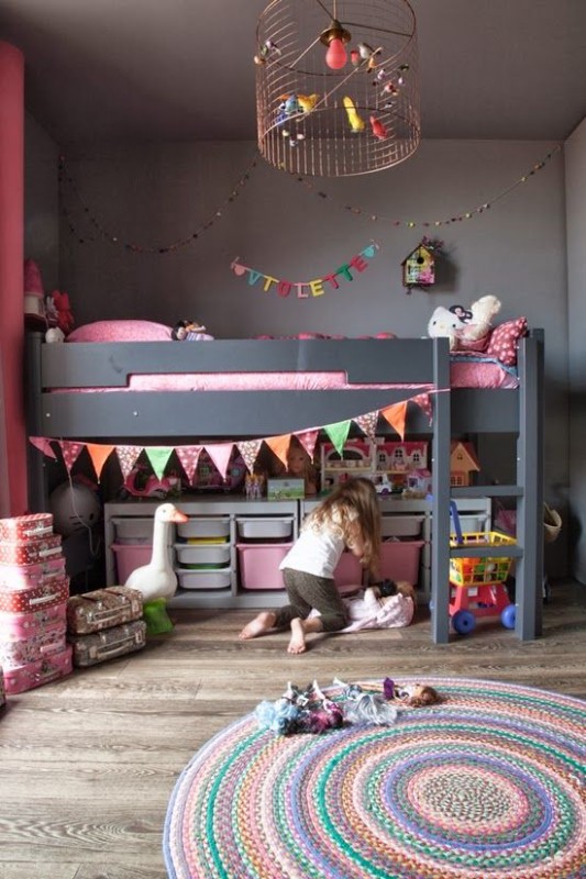 Dormitorio infantil decorado en gris y rosa con lámpara de hierro en el techo