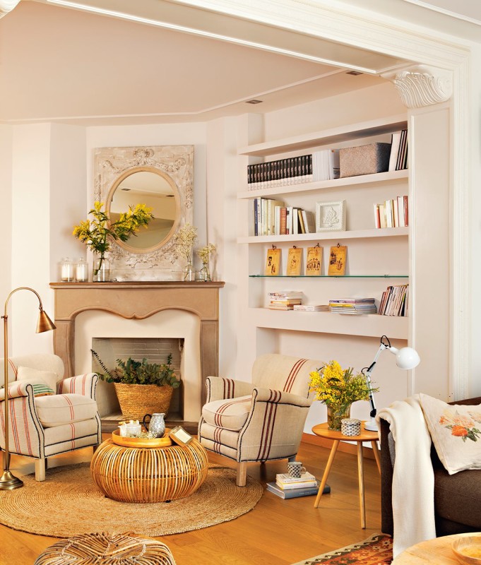 Rincón de lectura con chimenea, sillones y baldas en la pared para hacer el espacio más funcional