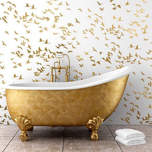Espacio baño con bañera y papel pared decorado con oro