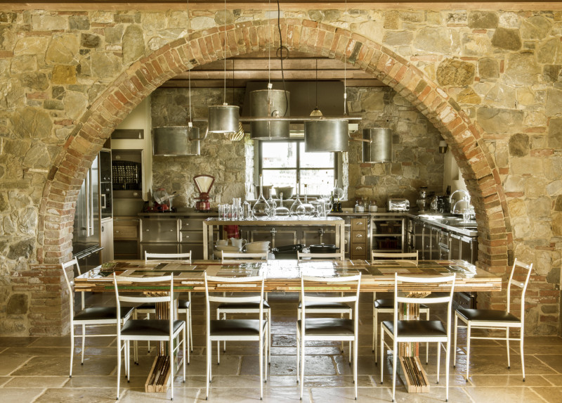Cocina de estilo industrial abierta al comedor se estilo moderno de la villa en la Toscana