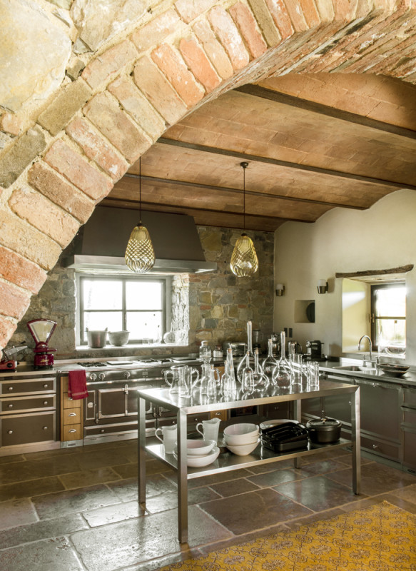 Vista de la cocina de estilo industrial con mobiliario de acero de la villa en la Toscana