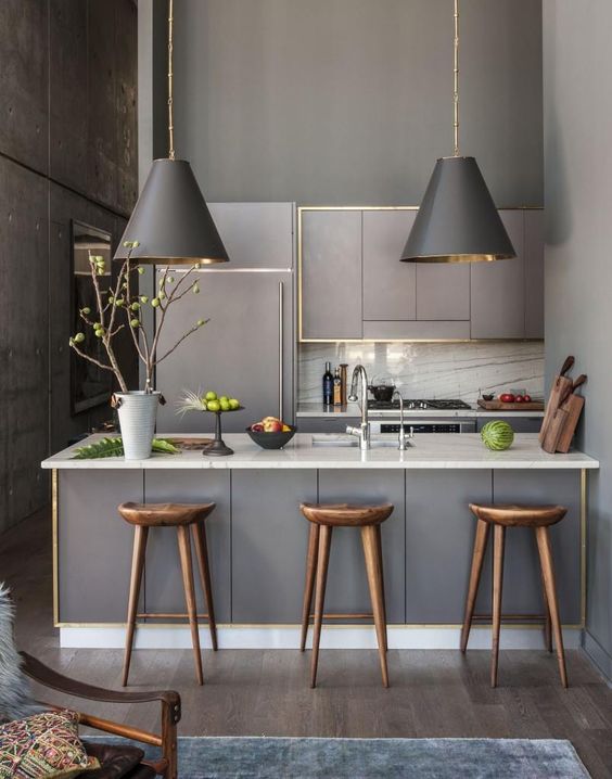 Cocina y espacio office decorado en gris y ribetes en oro