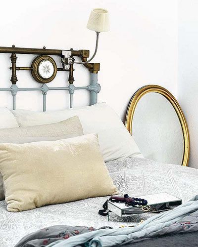 Dormitorio de estilo shabby con espejo con marco en oro
